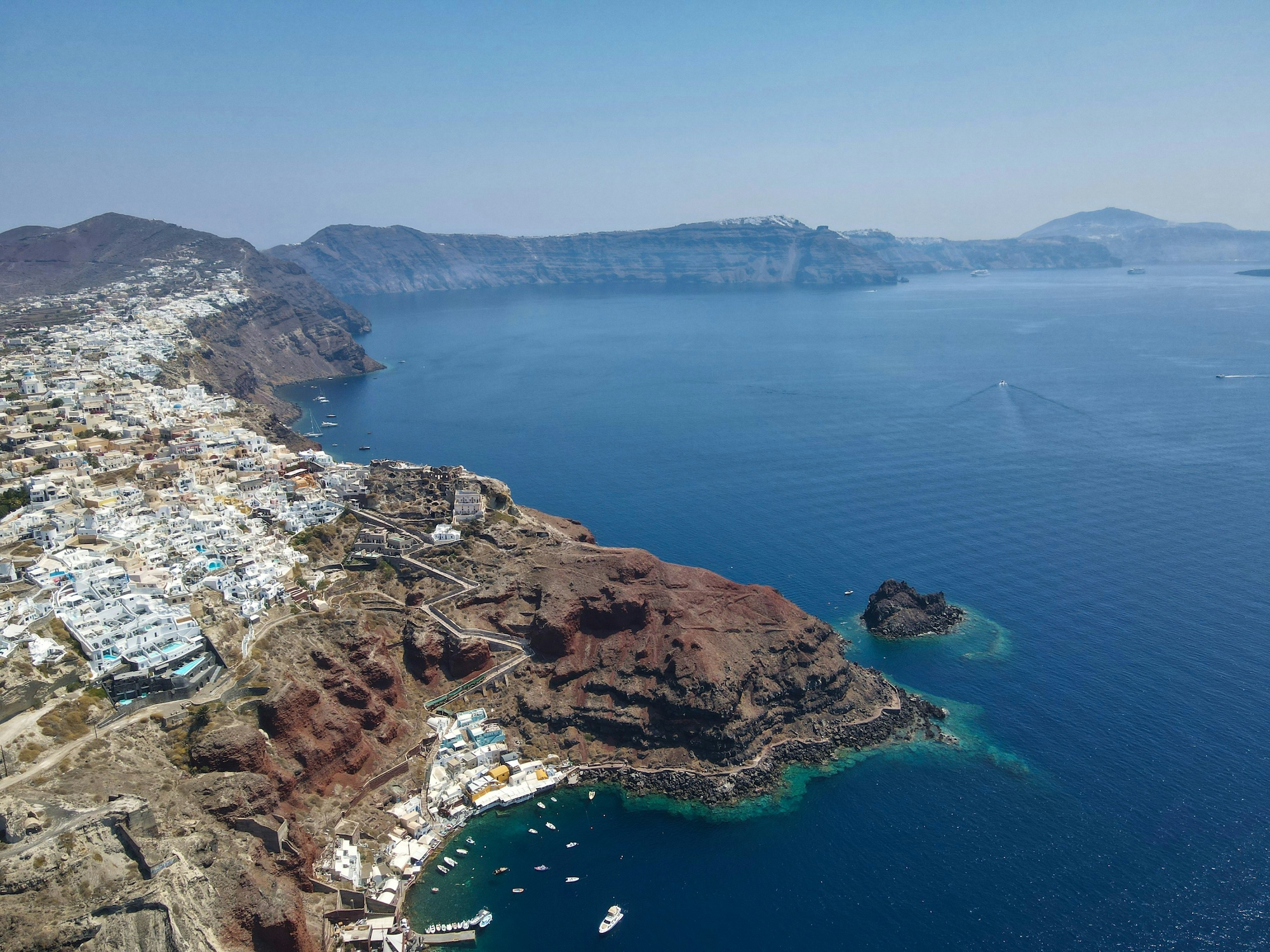 White hillside buildings overlooking Santorini’s caldera.